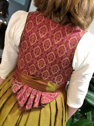 Rückansicht eines bunten Kleidungsstücks mit floralem Muster und tailliertem Schnitt.