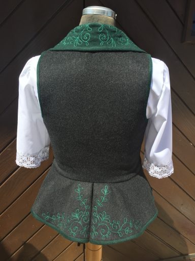 Dunkelgraue Trachtenjacke mit grünem Kragen und weißen Ärmeln.